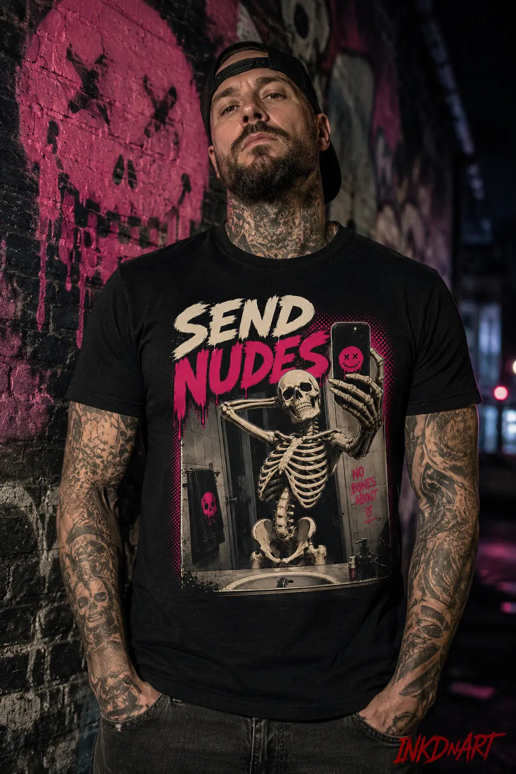 Send Nudes Tee – skeleton selfie graphic tee in bone and hot pink, worn by model against a neon pink wall